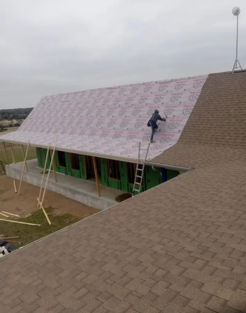Worker preparing underlayment for a metal roof installation in Park City